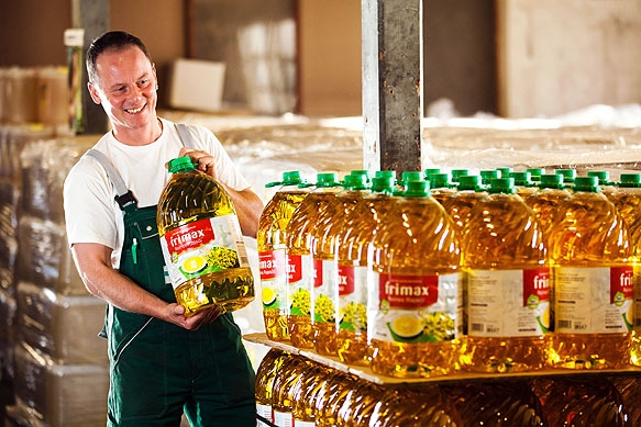 Daniel Dreyer, Mitarbeiter der Firma Sachsenfett, stappelt im Firmenlager Flaschen mit Öl